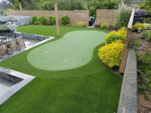 backyard putting green for golf. Surounded by a few bushes and walls